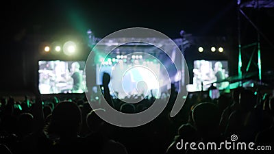 Serrez-vous sautent et dansent au festival de roche, bras augmentés des fans dans les lumières lumineuses de l'étape, mains de on banque de vidéos Serrez-vous sautent et dansent au festival de roche, bras augmentés des fans dans les lumières lumineuses de l'étape, mains de on banque de vidéos