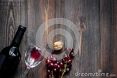Serve wine. Bottle, glass, nuts and grape on wooden table background top view copyspace Stock Photo
