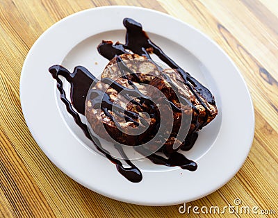 Served chocolate rolled cake with walnut on plate Stock Photo