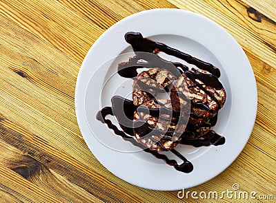 Served chocolate rolled cake with walnut on plate Stock Photo