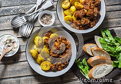 Served lunch table - irish beef stew with bombay turmeric potatoes. Delicious seasonal food on a wooden background, top view. Stock Photo