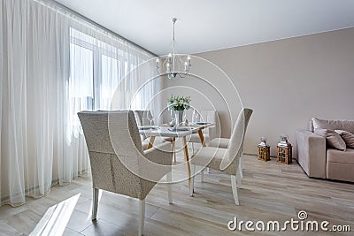 Served table with a bouquet of roses in interior of modern luxure guest room in studio apartments in minimalistic style Stock Photo