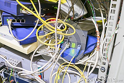 Server cabinet with network Internet equipment. Chaotic interlacing of wires between modems, switches and Internet bridges. Rack Stock Photo