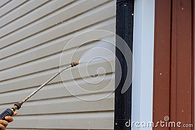 Service for cleaning siding houses on a regular basis by using high pressure nozzles that spray soap and water to clean Stock Photo