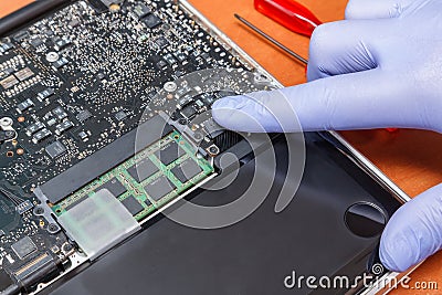 Service engineer install plug in new battery in to the laptop. Repairing laptop concept. Close up view Stock Photo