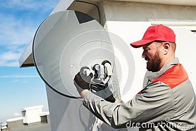 Service worker installing and fitting satellite antenna dish for cable TV Stock Photo