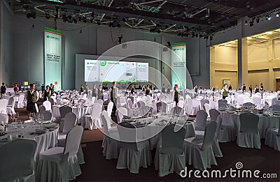 Service staff of Gorky Gorod resort ready to welcome guests standing still among round tables and chairs covered with white tablec Editorial Stock Photo