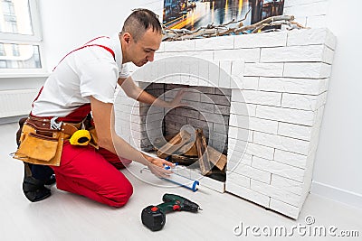 Service technician repairing a fireplace in a home Stock Photo