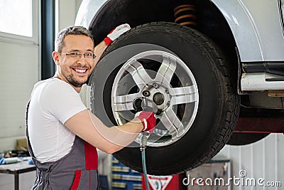 Serviceman in car workshop Stock Photo