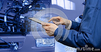 Serviceman with digital tablet on the background of the truck in the garage Stock Photo
