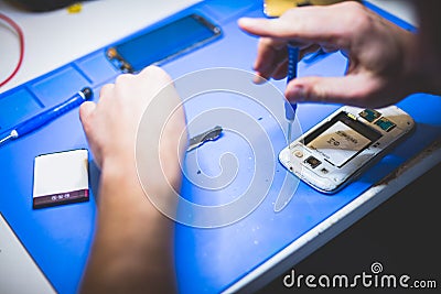 Serviceman fixing broken mobile phone Stock Photo