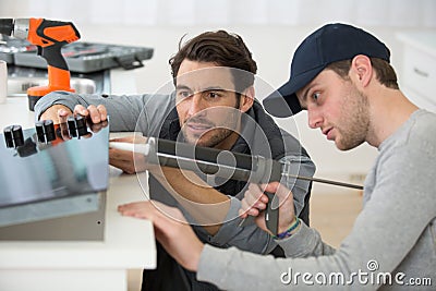 servicemen applying silicone whilst installing hob Stock Photo