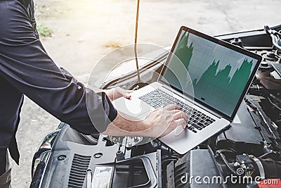 Services car engine machine concept, Automobile mechanic repairman checking a car engine with using computer diagnostics while Stock Photo