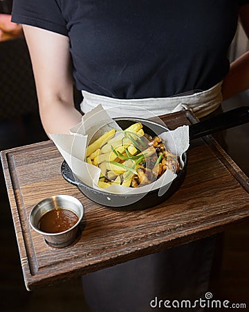 A Serving of french fries and deep fried snack with tomato sauce served by waiter in a plate. Stock Photo