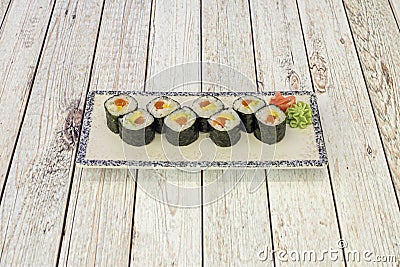 Serving tray of Norwegian salmon sushi with ripe avocado with Japanese rice, vinegar and sugar wrapped in nori seaweed Stock Photo