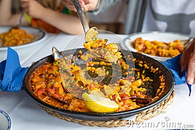 serving typical Spanish paella with mussels and clams in restaurant Stock Photo