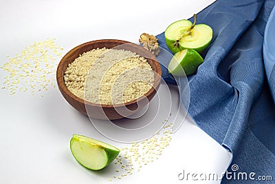 Sesame celulose in ceramic bowl, green apples isolated on white Stock Photo