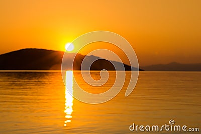 Sescape sunrise above calm water with island Stock Photo