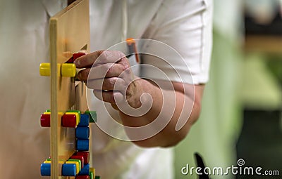 Nurse and physiotherapists helping elderly person to regain her body mobility, with toys Stock Photo