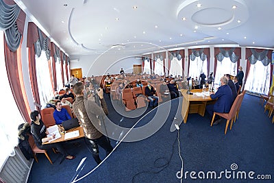 Session of regional council. Deputies sitting in a hall, speaker keeping speach at the tribune, head and his assistants sitting at Editorial Stock Photo