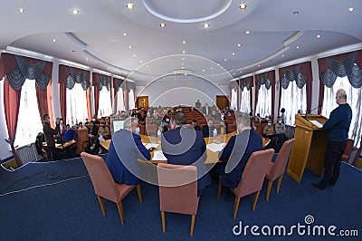 Session of regional council. Deputies sitting in a hall, speaker keeping speach at the tribune, head and his assistants sitting at Editorial Stock Photo