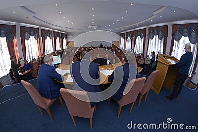 Session of regional council. Deputies sitting in a hall, speaker keeping speech at the tribune, head and his assistants Editorial Stock Photo