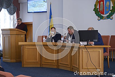 Session of regional council. Head center and his deputies with masks over faces sitting at the presidium and keeping speach Editorial Stock Photo