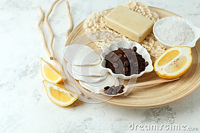 Set for anti-cellulite massage procedures. Coffee scrub, coffee grains, lemon, soap, sponge on wooden plate and gray background, Stock Photo