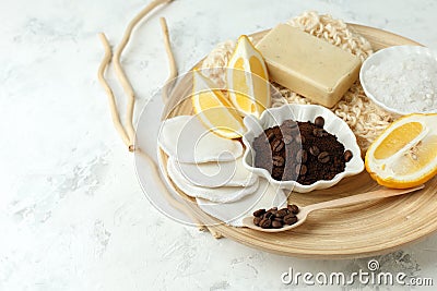 Set for anti-cellulite massage procedures. Coffee scrub, coffee grains, lemon, soap, sponge on wooden plate and gray background, Stock Photo