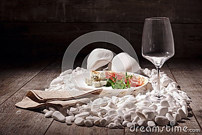 A set of appetizers on a wooden background. Wineglass and plate of meat and roquefore on white rocks. Luxury concept. Stock Photo