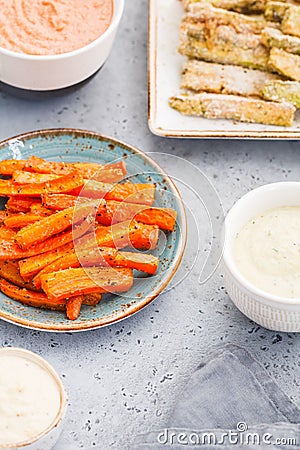 Set of baked season vegetable sticks of zucchini and carrots with sauce and hummus Stock Photo