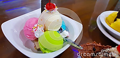 Set of bowls with various colorful Ice Cream scoops with different flavors and fresh ingredients, chocolate, vanilla, and Stock Photo