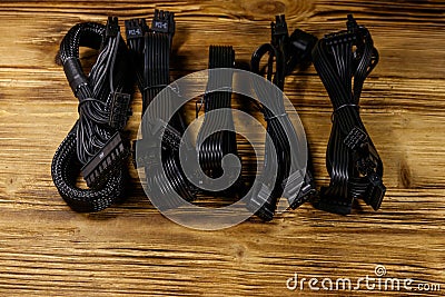 Set of cables for computer PSU on wooden desk Stock Photo