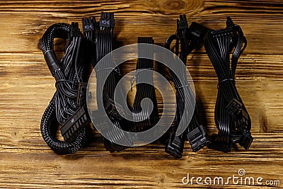 Set of cables for computer PSU on wooden desk Stock Photo