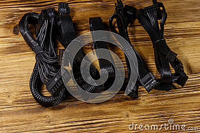 Set of cables for computer PSU on wooden desk Stock Photo