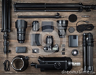 Set of the camera and photography equipment lens, tripod, filter, flash, memory card, hard desk, reflector on wood desk. Stock Photo