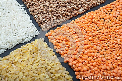 Set of cereals on a black background: lentils, rice, buckwheat and bulgur Stock Photo