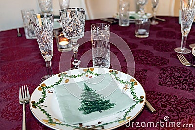 Set Christmas table with Christmas plate and crystal glasses. Stock Photo