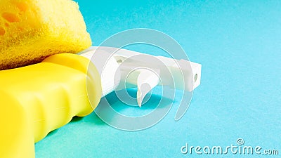Set of cleaning products on a blue background. Yellow rag and sponge, cleaning spray, detergent. House cleaning concept Stock Photo