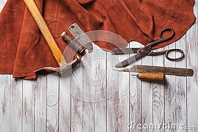 Set of cobbler tools on the light wooden background. Space for t Stock Photo