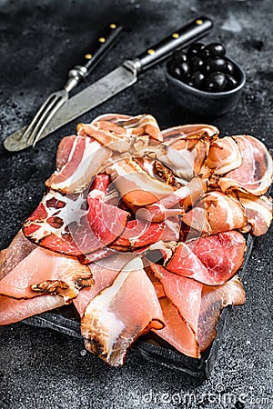 Set of cold cured italian meat Ham, prosciutto, pancetta, bacon. Black background. Top view Stock Photo