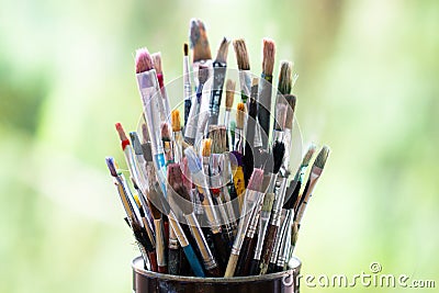 Set of color messy paint brushes in metal tin can on the window Stock Photo