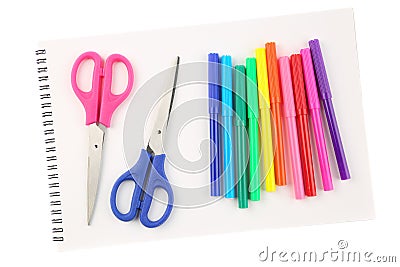 Set of colorful felt tip pens and two scissors on a blank, opened sketchbook sheet, isolated on white background. Art and creativi Stock Photo