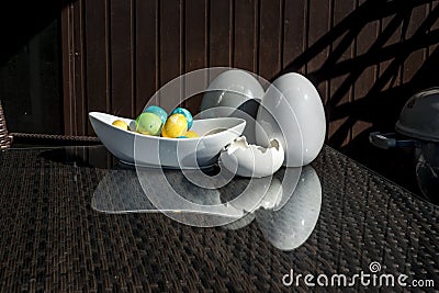 Set colorful shiny Easter eggs and grey and white colored ceramic and reflection on table Stock Photo