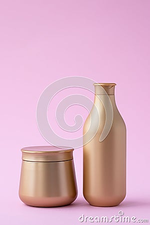 Set of cosmetic bottles with copy space, empty place for text. Golden flacon of shampoo and jar of mask on pink background. Hair Stock Photo