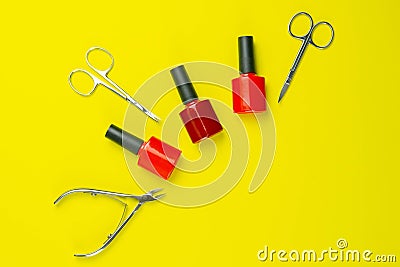 A set of cosmetic tools for manicure and pedicure. Manicure scissors, cuticles, saws, miller stand on a yallow background. Top Stock Photo