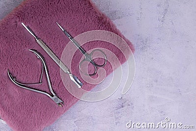 A set of cosmetic tools for manicure and pedicure stand on a pink fluffy notebook for recording clients. tweezers, scissors and Stock Photo