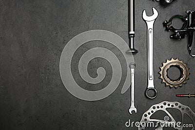 Set of different bicycle tools and parts on stone table, flat lay. Space for text Stock Photo