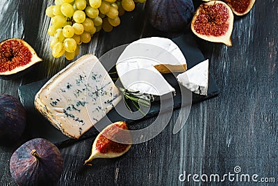 Set of different cheeses on a wooden rustic background. cheese plate on the table. Variety of cheeses with honey, grapes, walnuts Stock Photo