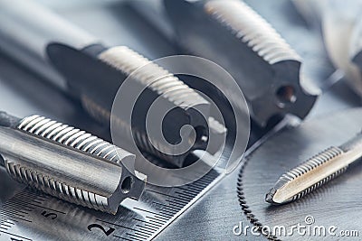 Set of different drill bits,thread taps and mill cutters with ruler on steel plate background. Locksmithing deal Stock Photo